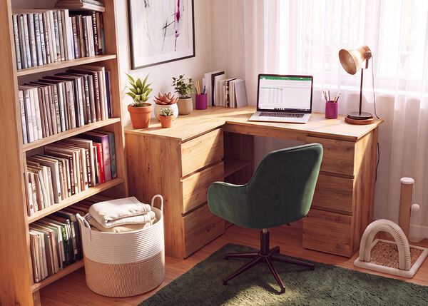 Homeoffice mit Eckschreibtisch aus Holz, ergonomischem gr&uuml;nem B&uuml;rostuhl, Laptop, B&uuml;cherregal, Schreibtischlampe und Zimmerpflanzen. So entsteht ein bequemer und produktiver Arbeitsplatz f&uuml;r zu Hause.
