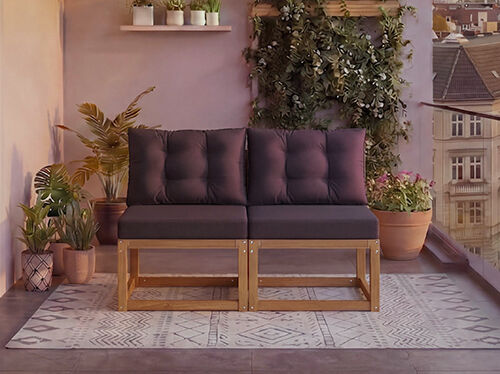 Zweiteiliges modulares Holzsofa mit dunkelgrauen Kissen auf einem Balkon mit Topfpflanzen und Stadtblick im Hintergrund