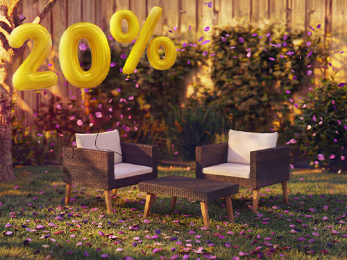 Canap&eacute; lounge d&rsquo;ext&eacute;rieur en bambou avec coussins gris et table basse assortie dans un cadre de jardin, entour&eacute;s de confettis roses et de ballons dor&eacute;s indiquant une remise de 20 %, pour promouvoir des offres saisonni&egrave;res sur le mobilier lounge d&rsquo;ext&eacute;rieur.