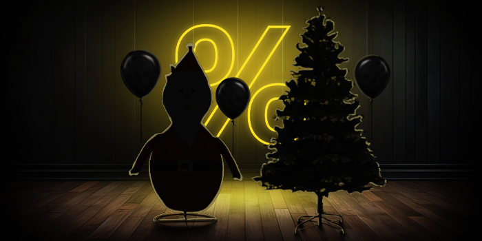  Aufblasbare Weihnachtsmannfigur und Weihnachtsbaum mit schwarzen Ballons vor einem leuchtend gelben Prozentzeichen auf dunklem Holzboden.