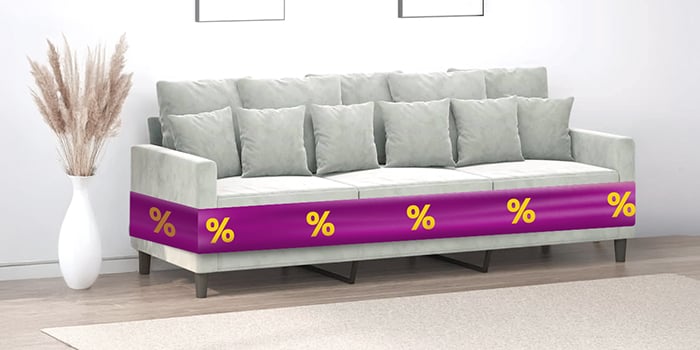 Graues Dreisitzer-Sofa mit Kissen und lila Band mit Rabattsymbolen, in einem stilvoll eingerichteten Wohnzimmer. Klick drauf, um die Produkte im Angebot zu kaufen.