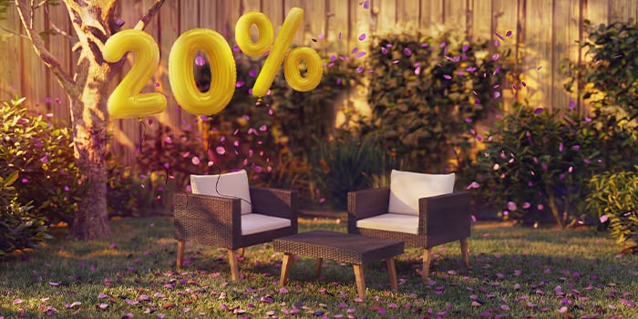 Canapé lounge d’extérieur en bambou avec coussins gris et table basse assortie dans un cadre de jardin, entourés de confettis roses et de ballons dorés indiquant une remise de 20 %, pour promouvoir des offres saisonnières sur le mobilier lounge d’extérieur.